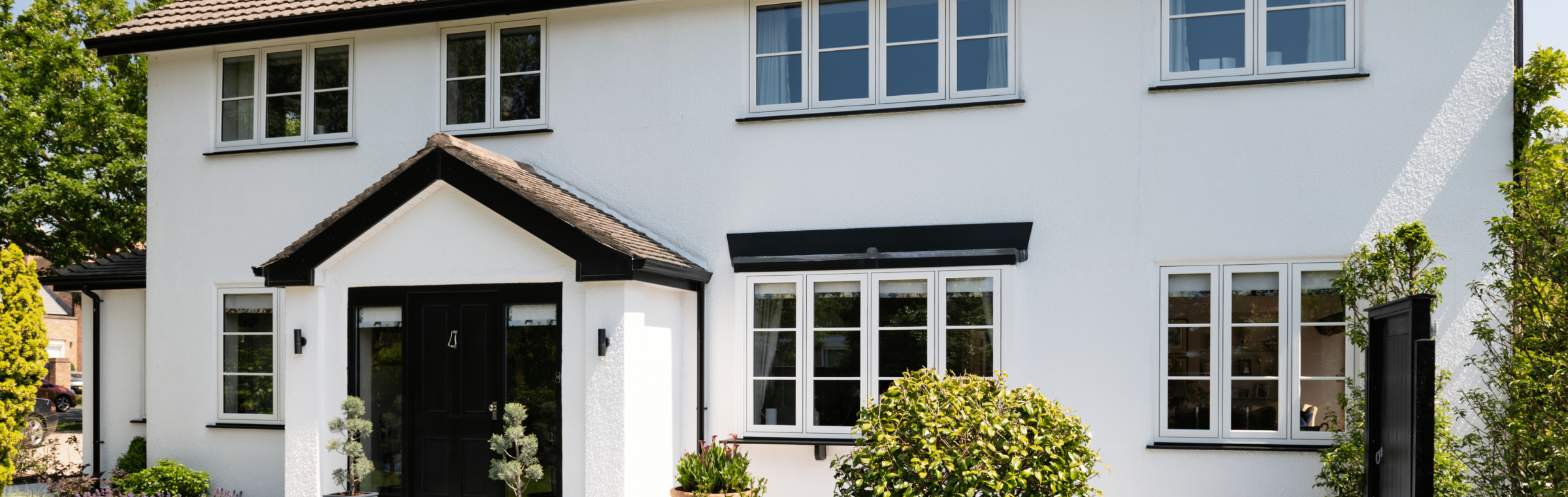 white rendered house with black doors and white windows